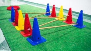 Tor przeszkód składający się z kolorowych pachołków połączonych drewnianymi kijami.